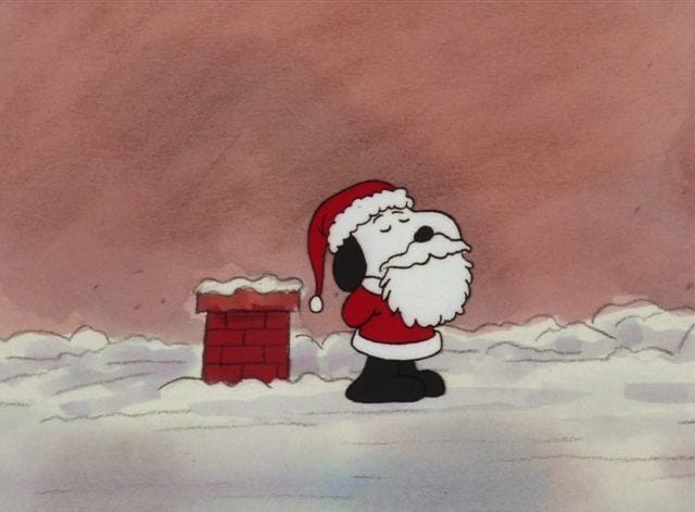 This may contain: a santa clause is standing in the snow next to a red brick wall and chimney