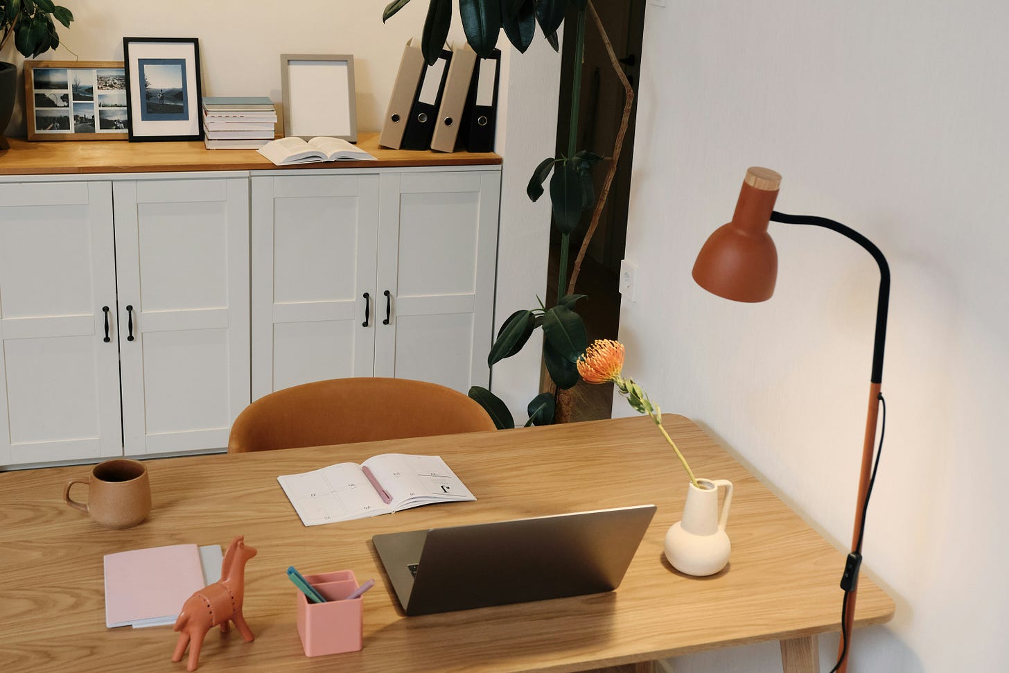 Minimalist home writing desk setup with laptop, planner, and cozy decor — representing the dream writing life built through freelance work, daily discipline, and creative freedom.