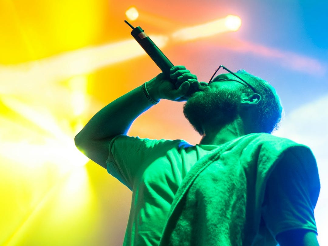 man singing while holding microphone man singing while holding microphone