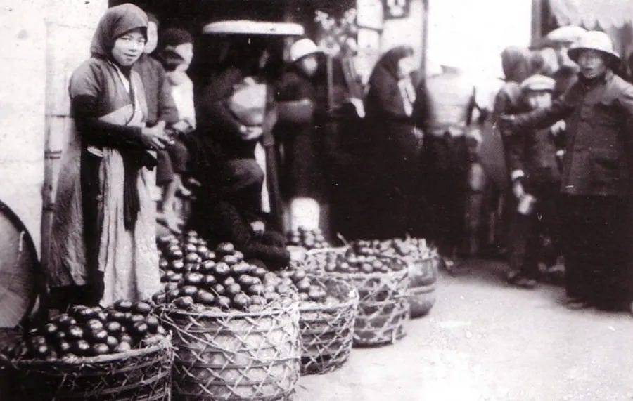 A vendor selling fruit in a market. 1905