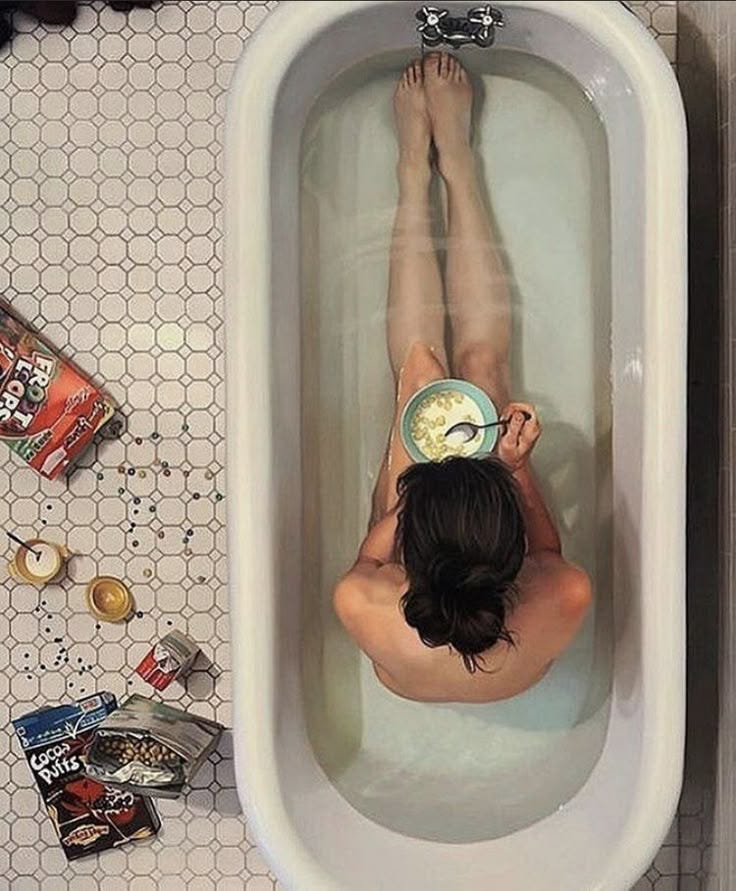 This may contain: a woman laying in a bathtub with a clock on her head and other items around