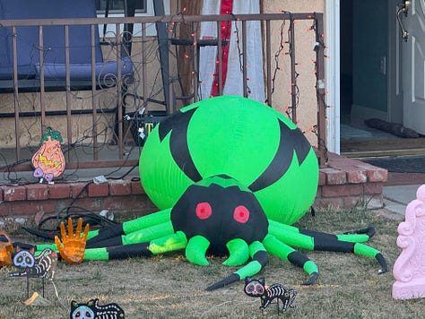 Various Halloween displays--including witches, skeletons, spiders, and a talking medieval knight--in front yards along Santa Paula Street.