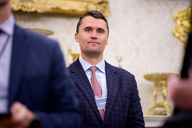 Turning Point USA co-founder Charlie Kirk stands in the back of the room as U.S. President Donald Trump speaks during a swearing in ceremony for...