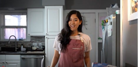 A person standing in a kitchen

Description automatically generated