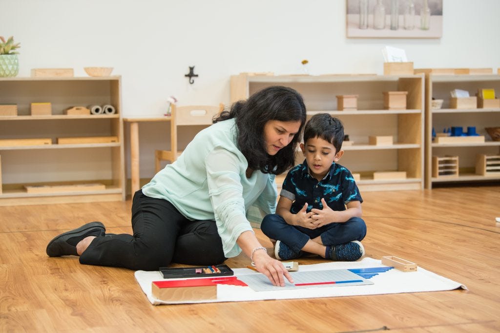 Montessori guide working one-on-one with child on floor mat, what AI learning cannot replace