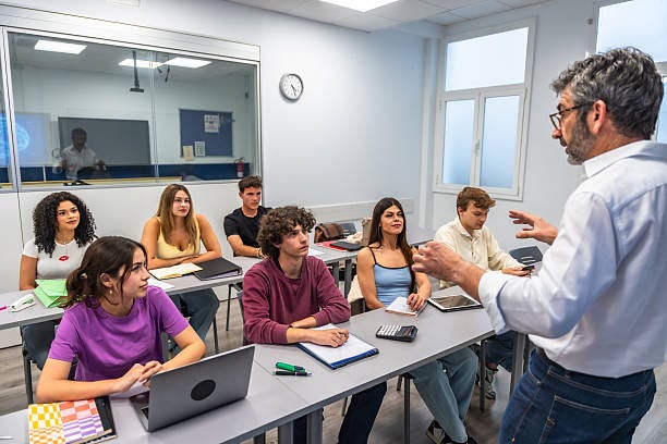 Professor lecturing students in a modern university classroom