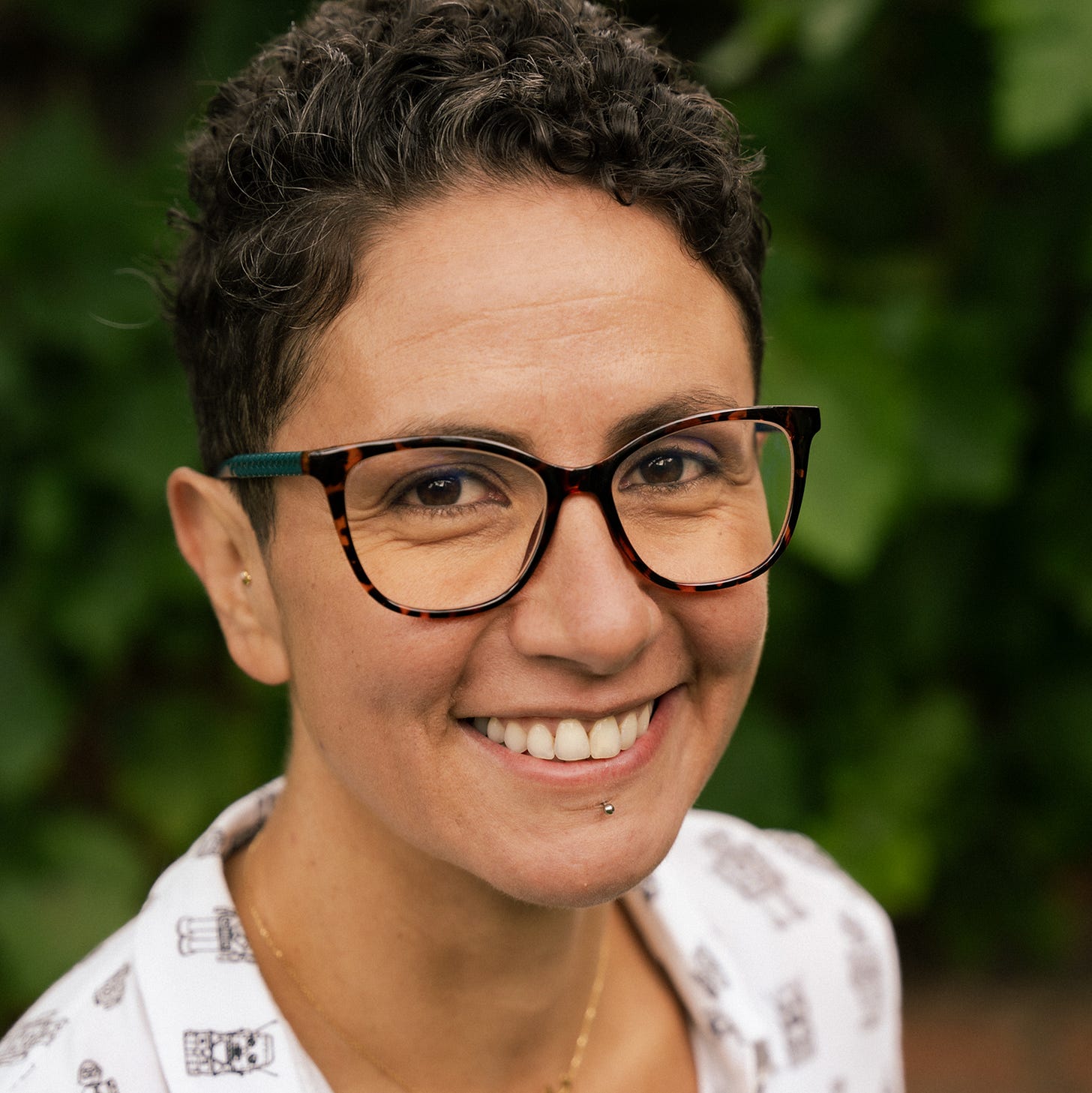 In a portrait, Dr. Dima Saber smiles at the camera while wearing glasses.