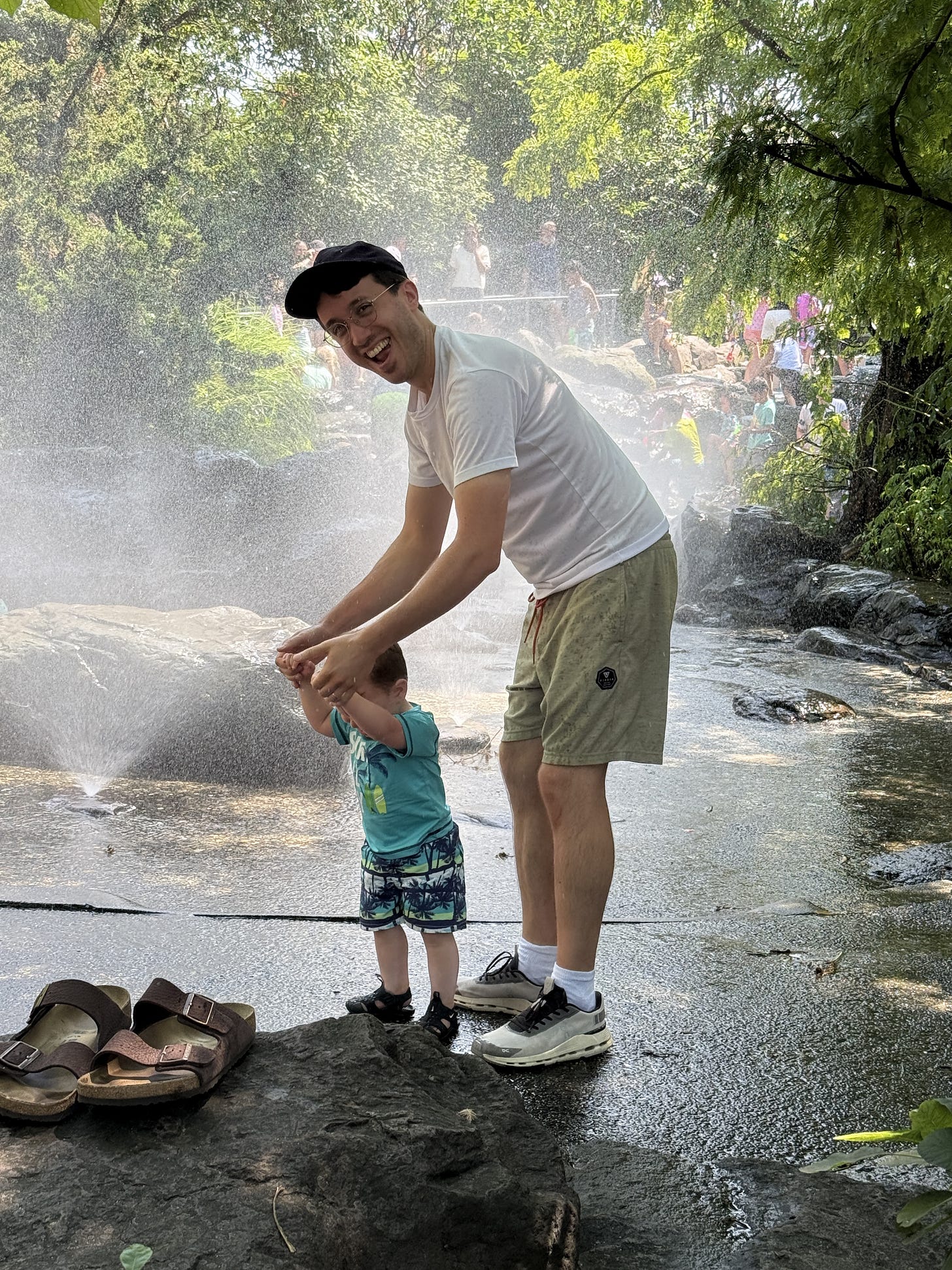 Cameron Faulkner and his kid standing in some water and smiling