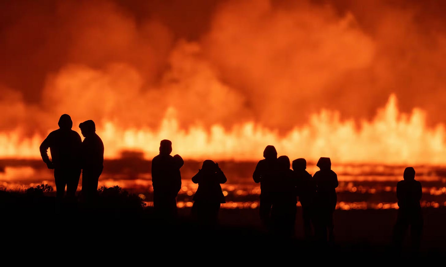 People watch the eruption from the road to Grindavík. Photograph: Marco di Marco/AP People watch the eruption from the road to Grindavík. Photograph: Marco di Marco/AP