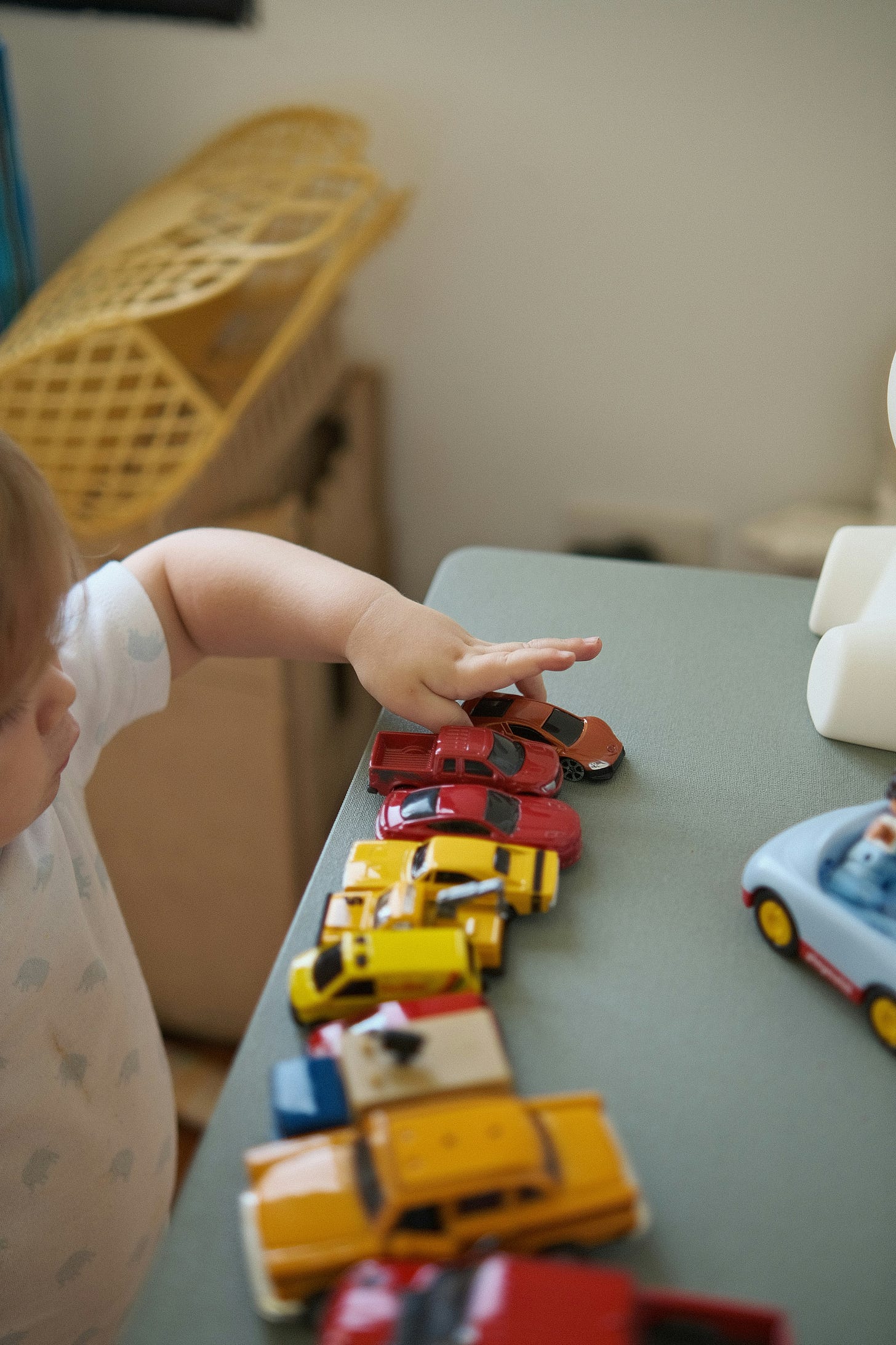 a small boy lining up toy cars