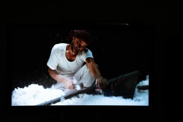 Still from Reetu Sattar’s film ‘Shabnam’ showing a male worker in white cotton clothes washing cotton fibre. Still from Reetu Sattar’s film ‘Shabnam’ showing a male worker in white cotton clothes washing cotton fibre.