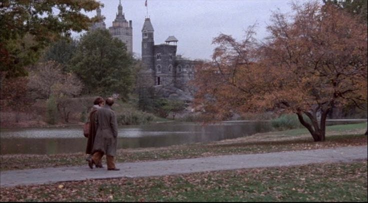 This may contain: a man walking down a path next to a river in the rain with an old castle in the background This may contain: a man walking down a path next to a river in the rain with an old castle in the background