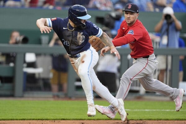 Kansas City Royals' Kyle Isbel is tagged out by Boston Red Sox third baseman Alex Bregman after getting caught off base for the first out of a double play on a fielder's choice hit by Jonathan India during the fifth inning of a baseball game, Friday, May 9, 2025, in Kansas City, Mo. (AP Photo/Charlie Riedel)