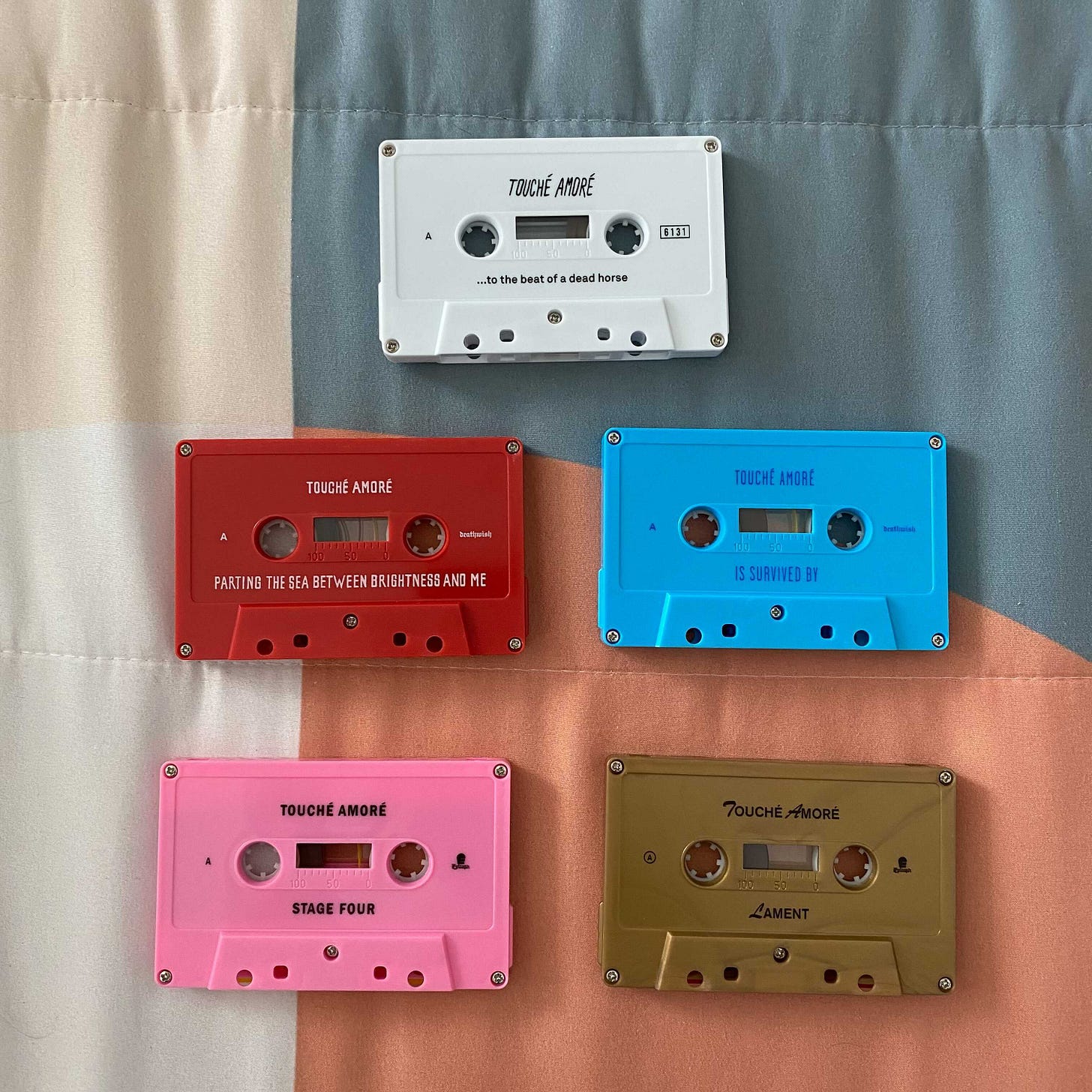 a picture of the five Touché Amoré albums on cassette tapes