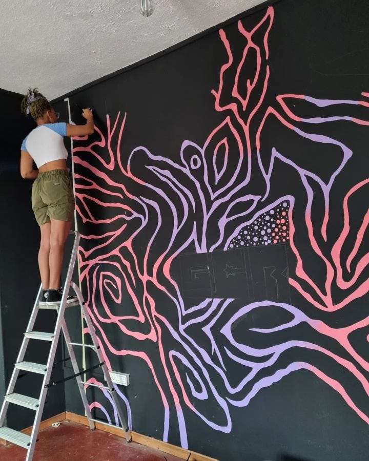 Viola painting a mural for the Gold Coast Report Office, Osu