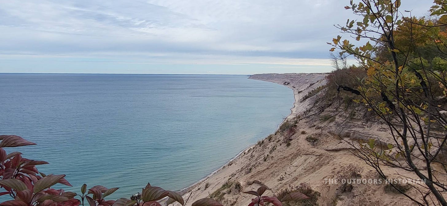 A distant view of the Grand Sable Dunes stretching along the coastline as seen from the Log Slide.