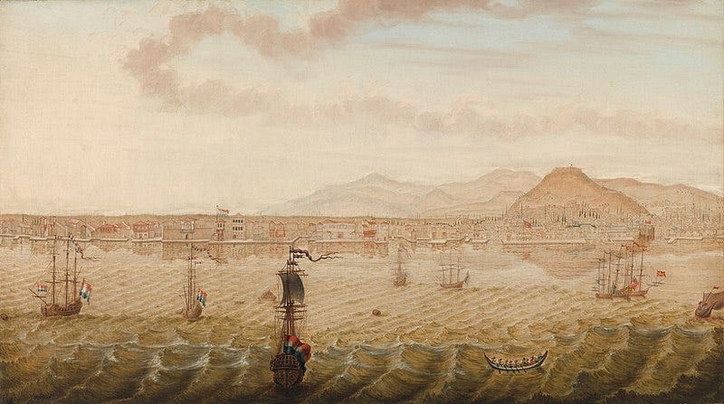 A scene of a distant harbour behind which is a distinctive conical hill. In the foreground are sailing ships, some displaying Dutch flags.