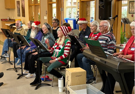 A group of people sitting in chairs singing

AI-generated content may be incorrect.