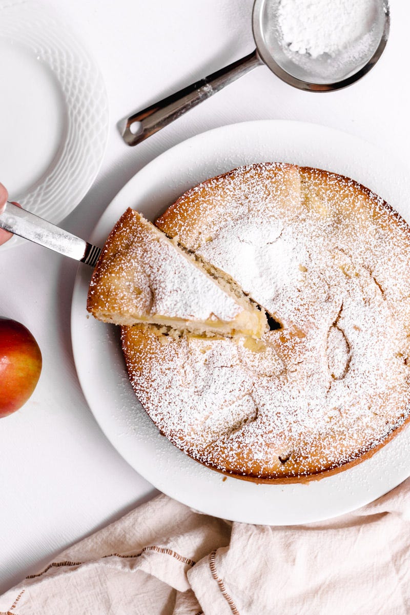 overhead image of an apple cake on a white plate.
