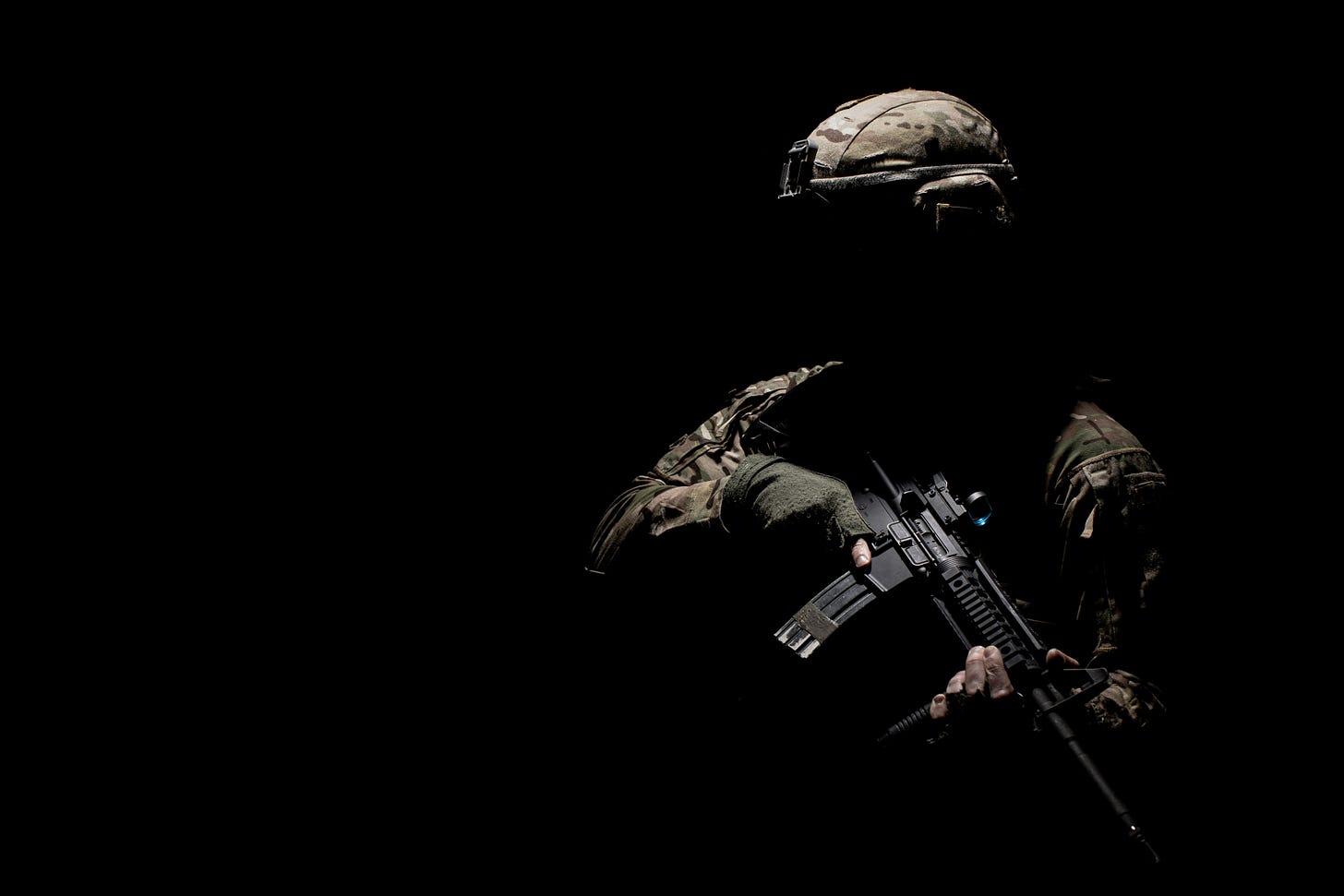 A dark photograph of a solider holding a gun