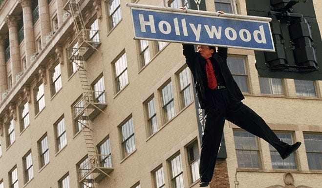 Jackie Chan hangs from the Hollywood Blvd. street sign in Rush Hour Jackie Chan hangs from the Hollywood Blvd. street sign in Rush Hour