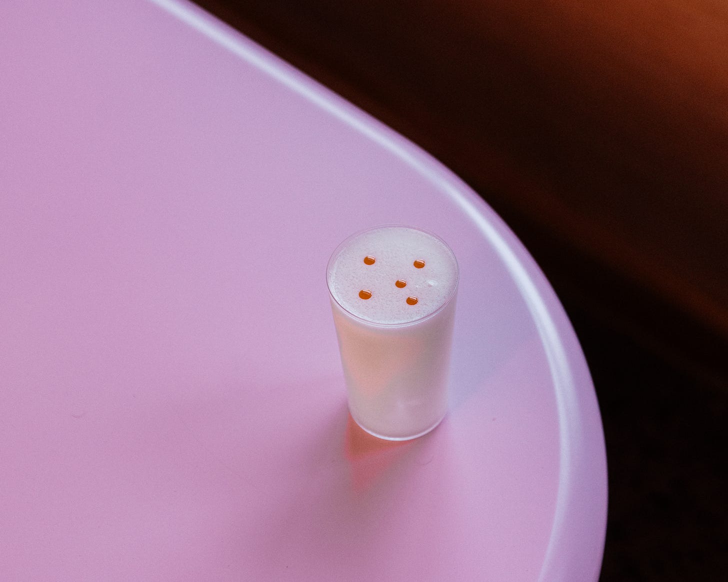 Schmuck’s Larb Gai cocktail on a pink table.