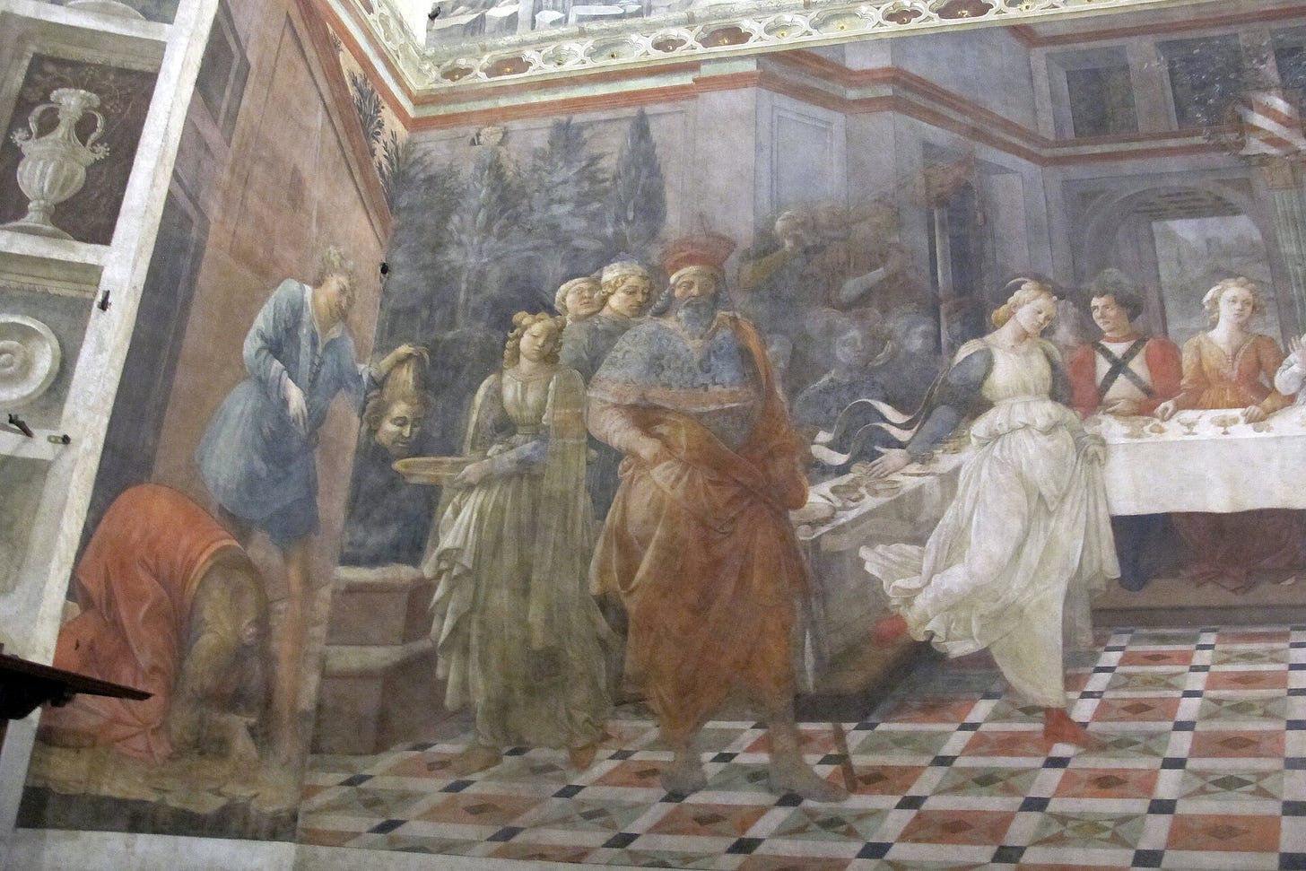 A long banquet fresco: in the center a young woman in a pale flowing dress dances alone on a tiled floor, while guests sit at a table on the right and, on the left, a kneeling girl offers a dish to a seated woman.
