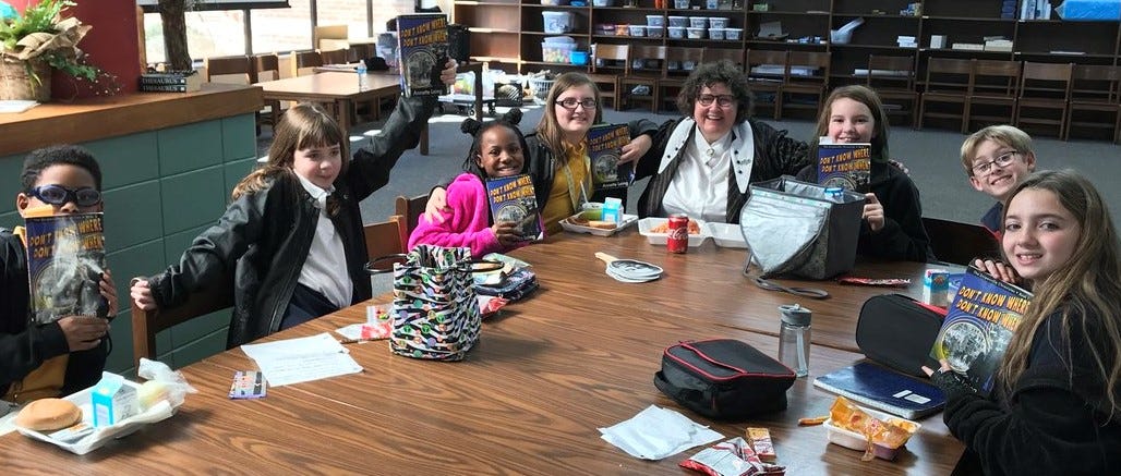 Annette with kids and copies of her books