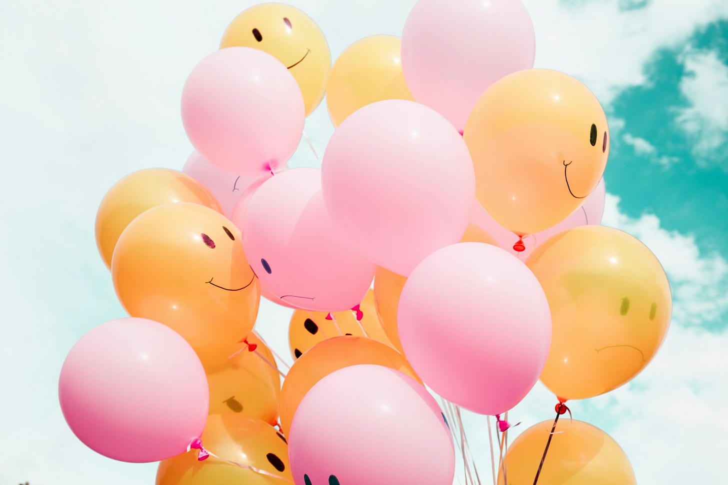 Colorful balloons, some with happy faces and others sad Colorful balloons, some with happy faces and others sad