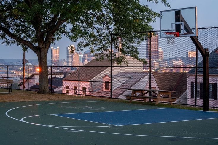 This may contain: an outdoor basketball court with a view of the city in the backgrouds This may contain: an outdoor basketball court with a view of the city in the backgrouds