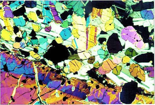 Image of a moonrock as seen through a petrographic microscope. There is a rainbow of colors.