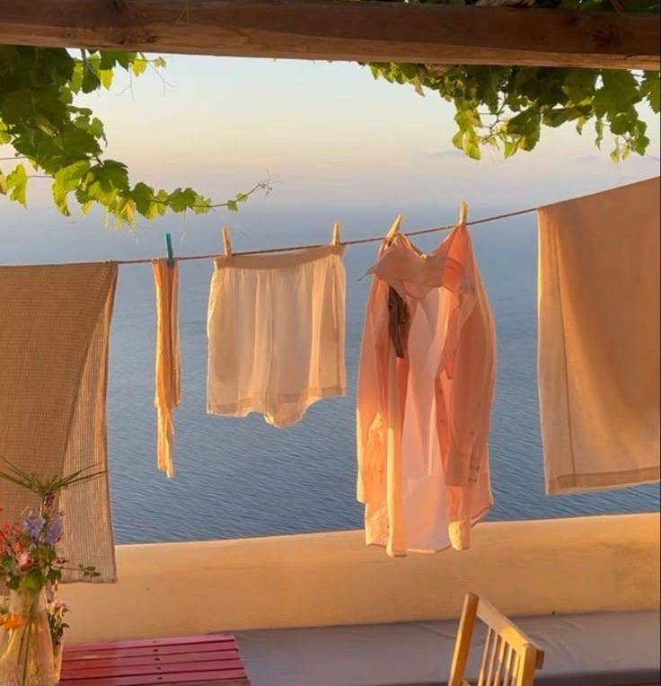 This may contain: clothes hanging out to dry in the sun on a balcony overlooking the ocean and water This may contain: clothes hanging out to dry in the sun on a balcony overlooking the ocean and water