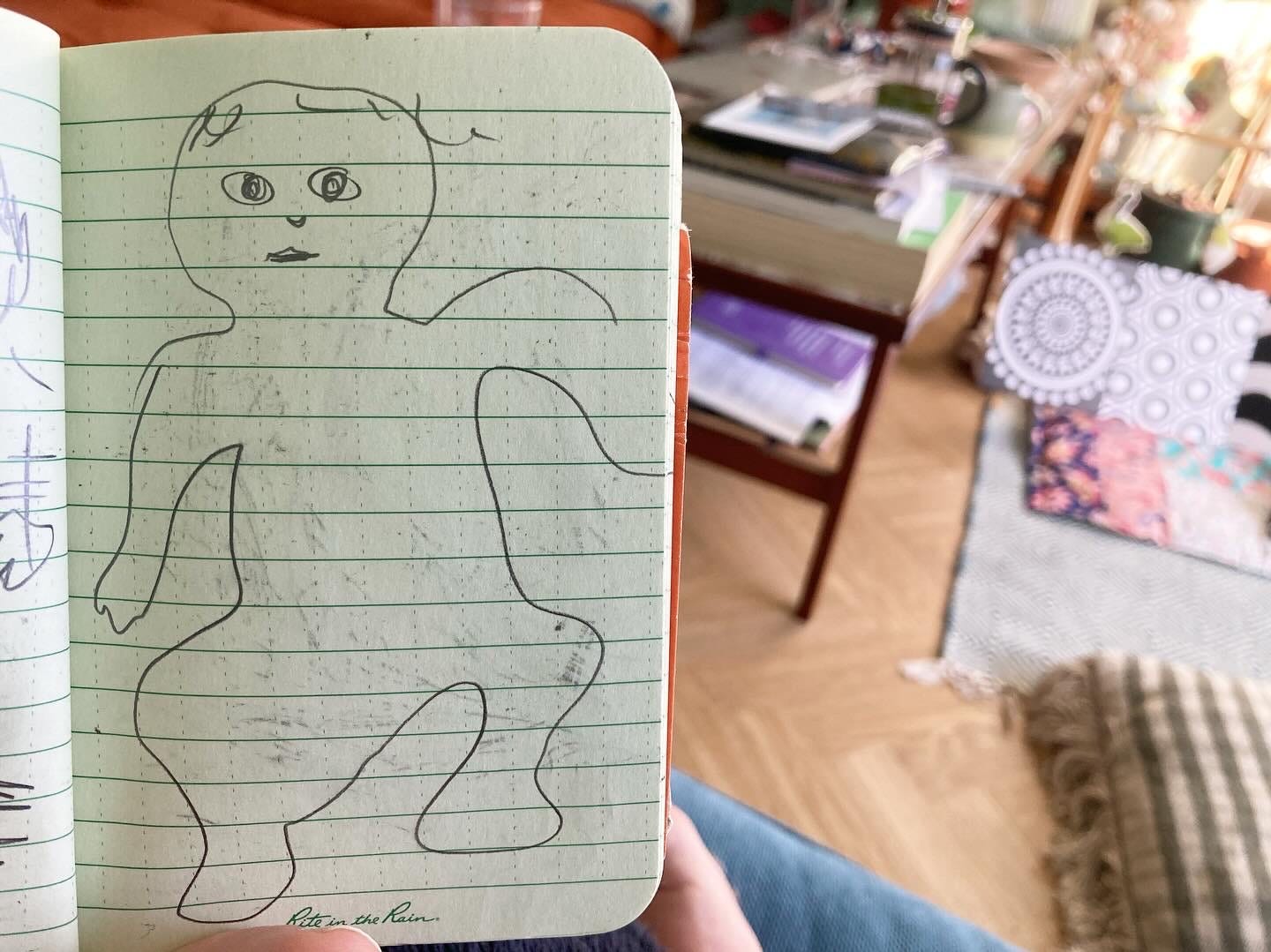 Wiggly pencil drawing of a baby in a sketchbook