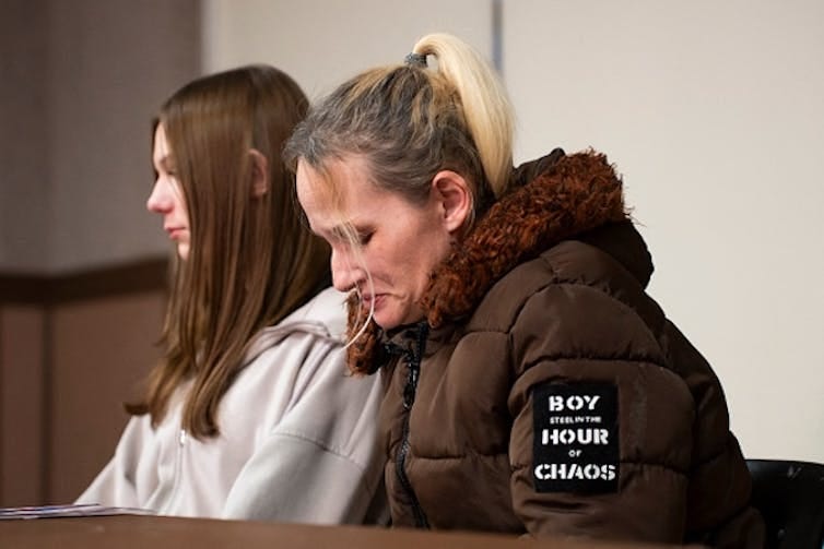 two seated women appear to be grieving
