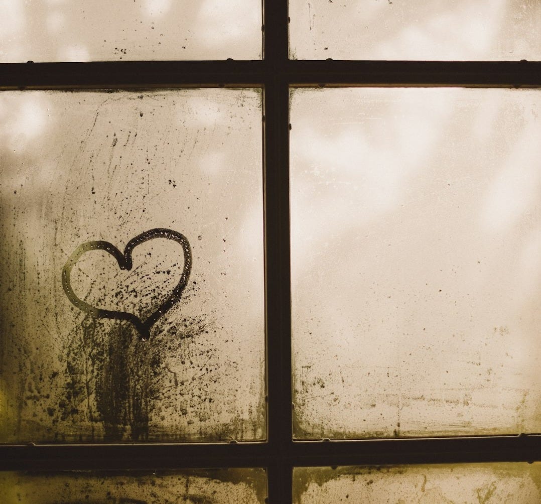 black framed glass window with heart draw