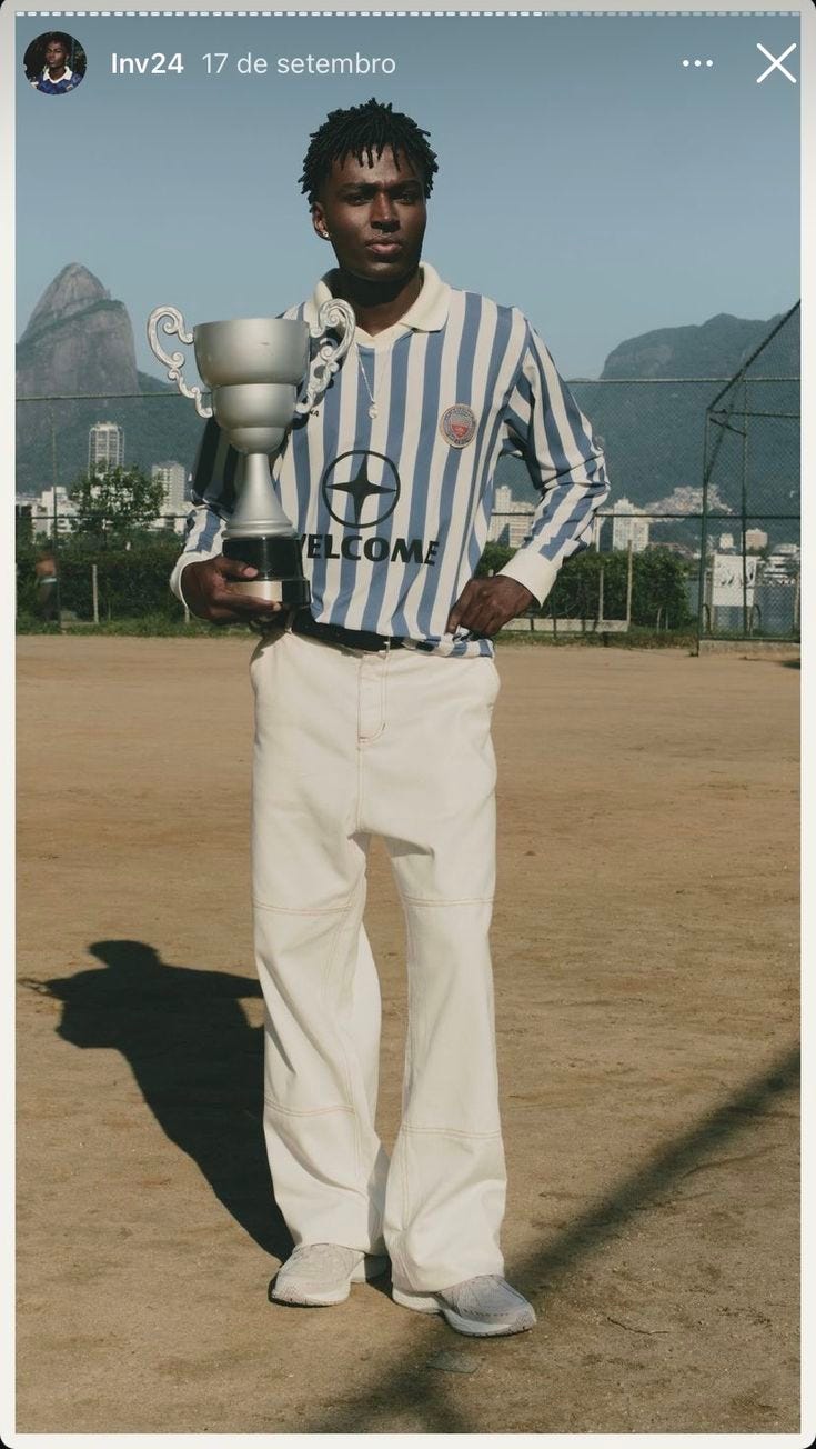 This may contain: a man in striped shirt holding up a trophy