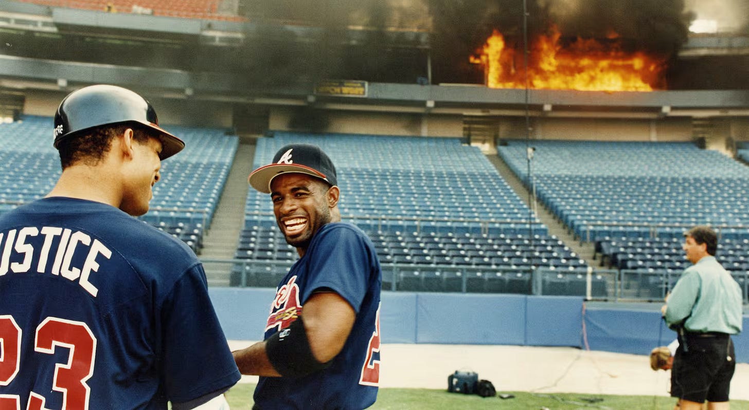 David Justice and Deion Sanders photographed with the stadium fire in the background.
