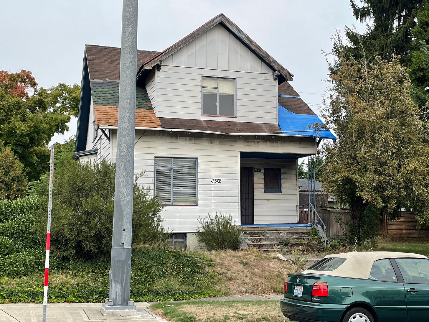 A neglected frame house is shown