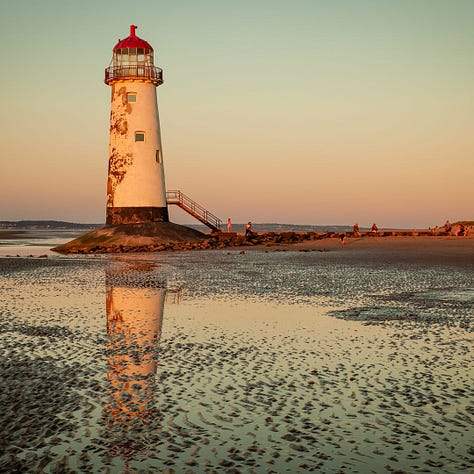 A gallery of three photographs showing different Welsh lighthouses. From left to right: the stark white tower of Nash Point standing on a green clifftop; the red and white striped Point of Ayr lighthouse resting on a sandy beach at sunset; and the rustic, cast-iron Whiteford Point lighthouse surrounded by expansive tidal flats.