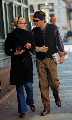 This may contain: a man and woman walking down the street