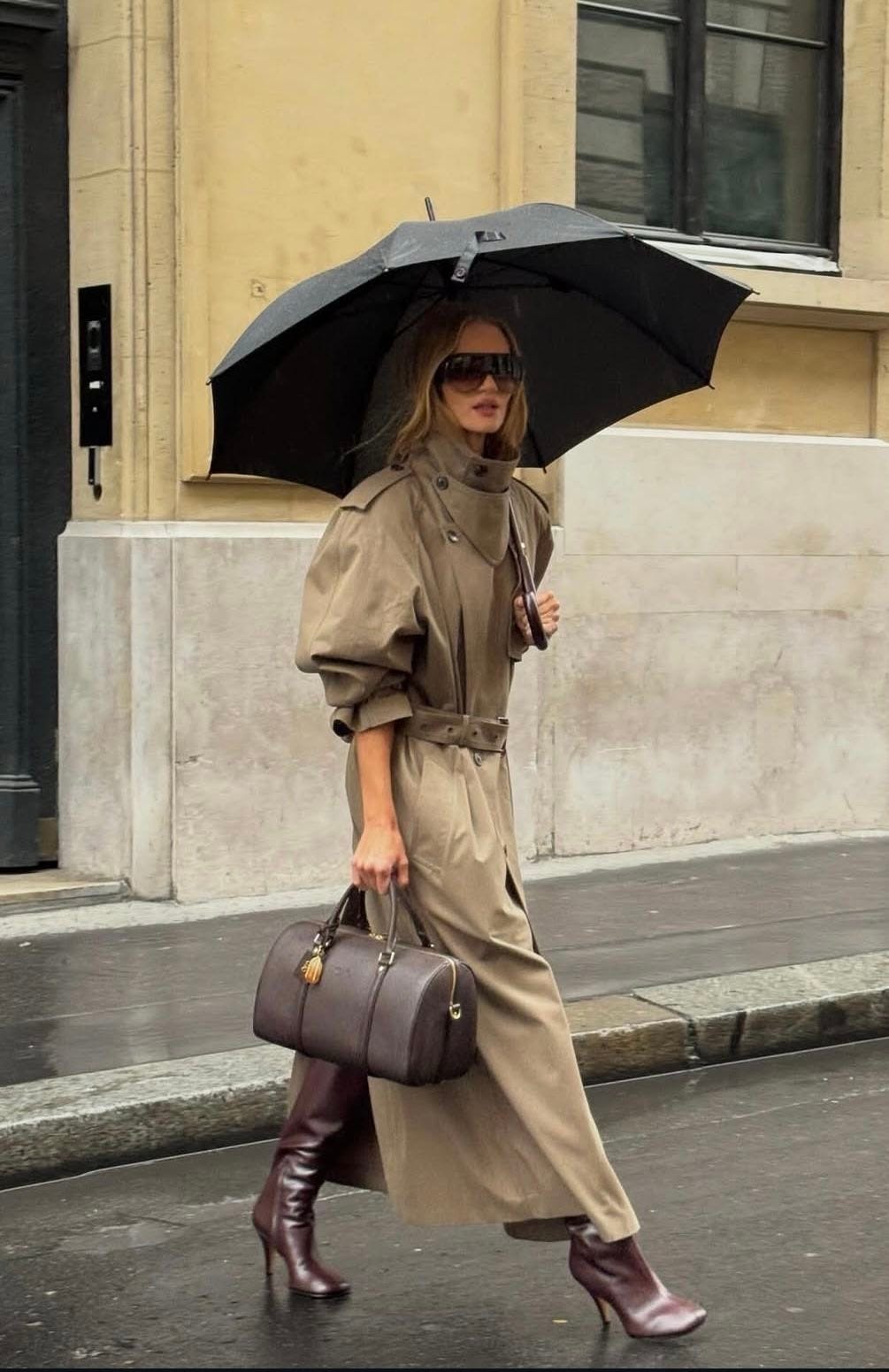 Look de mujer real paseando con trench cuello funnel, bolso y paraguas