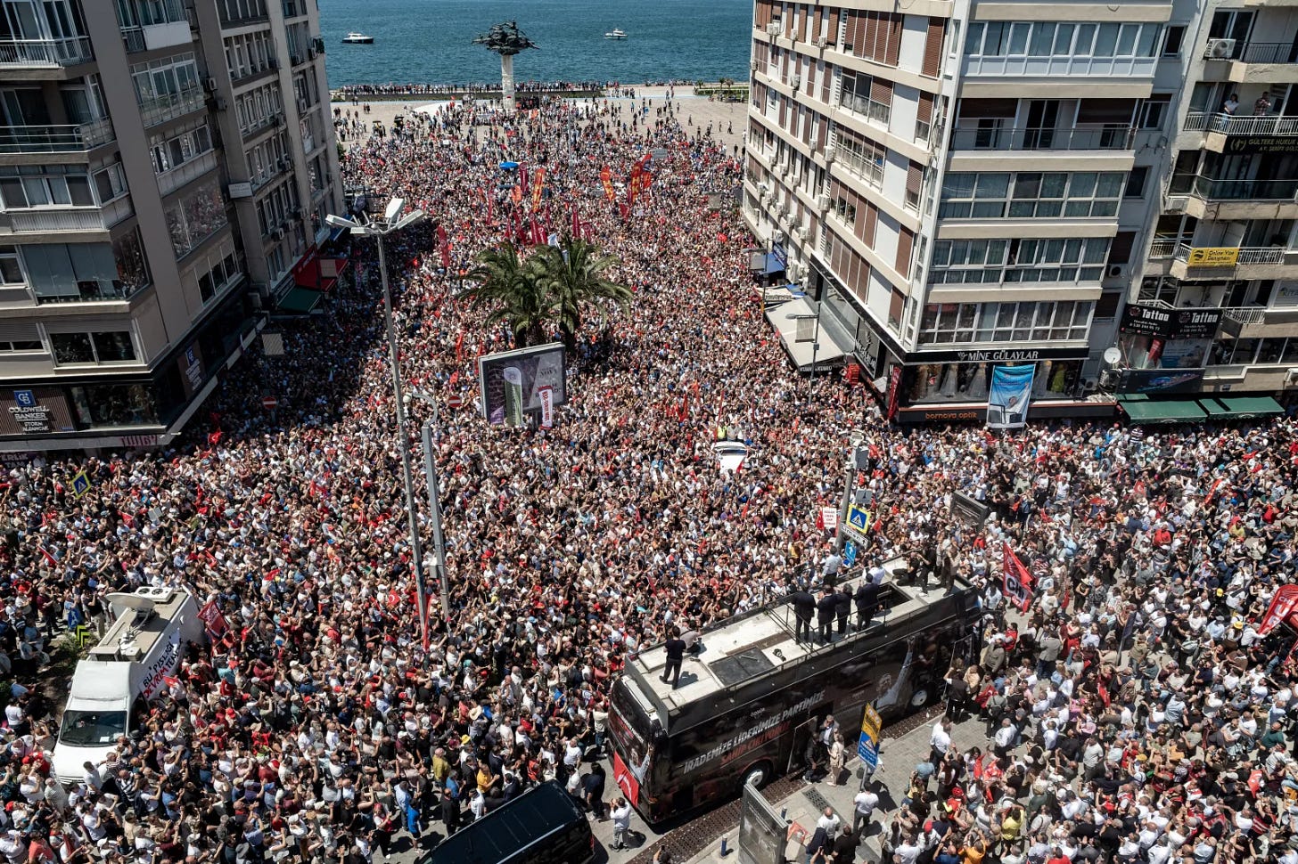 Turkey's Republican People's Party (CHP) ousted leader Özgür Özel stands atop of a bus as he delivers a speech during a rally, days after a court dismissed him from office in Izmir on May 26, 2026. The protest came two days after police battered their way into the CHP's headquarters in Ankara, firing tear gas and beating party members before throwing them out, Özel told AFP. (Photo by Murat Kocabas / AFP via Getty Images)