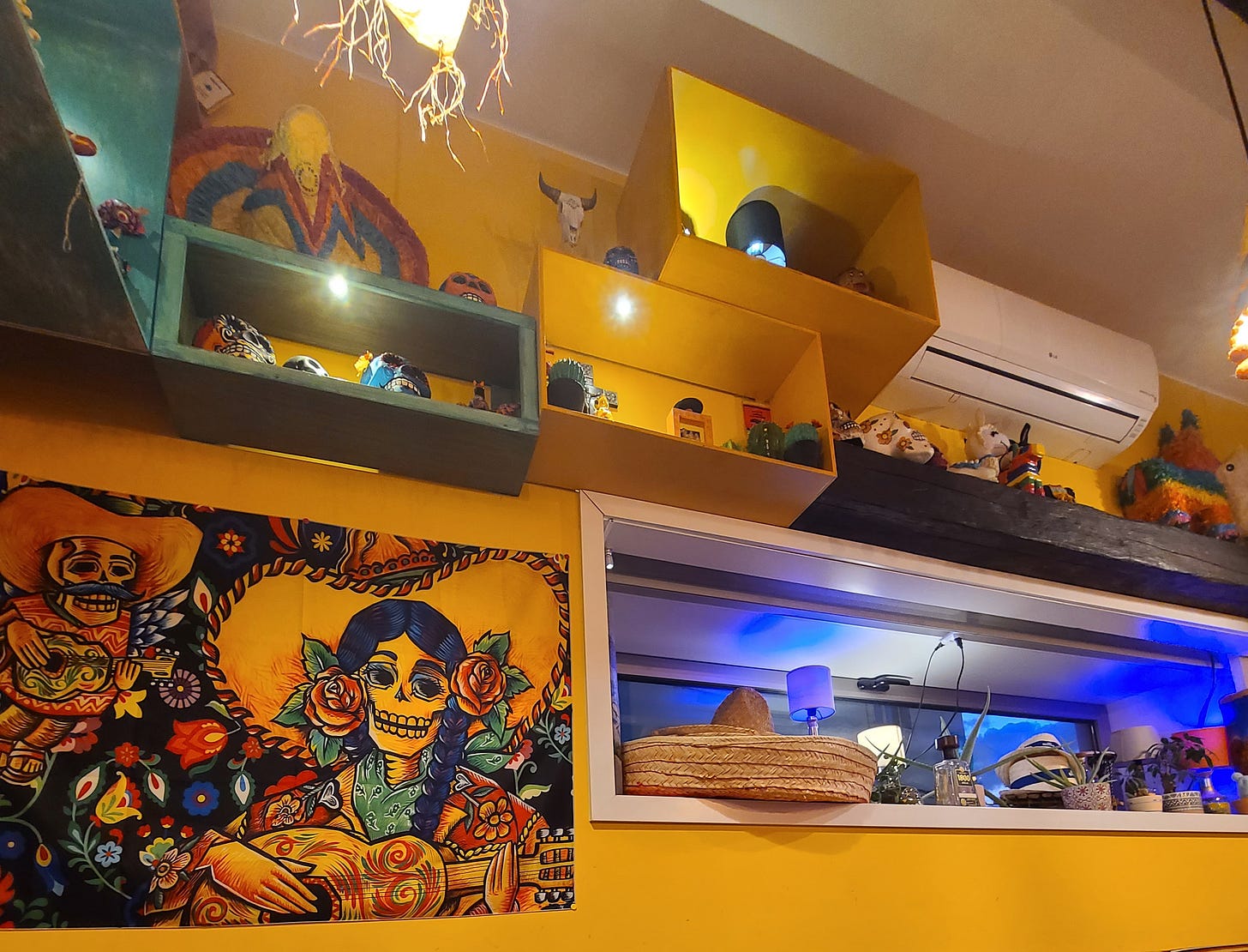 yellow wall with Dia de los Muertos art and Mexican handcrafts