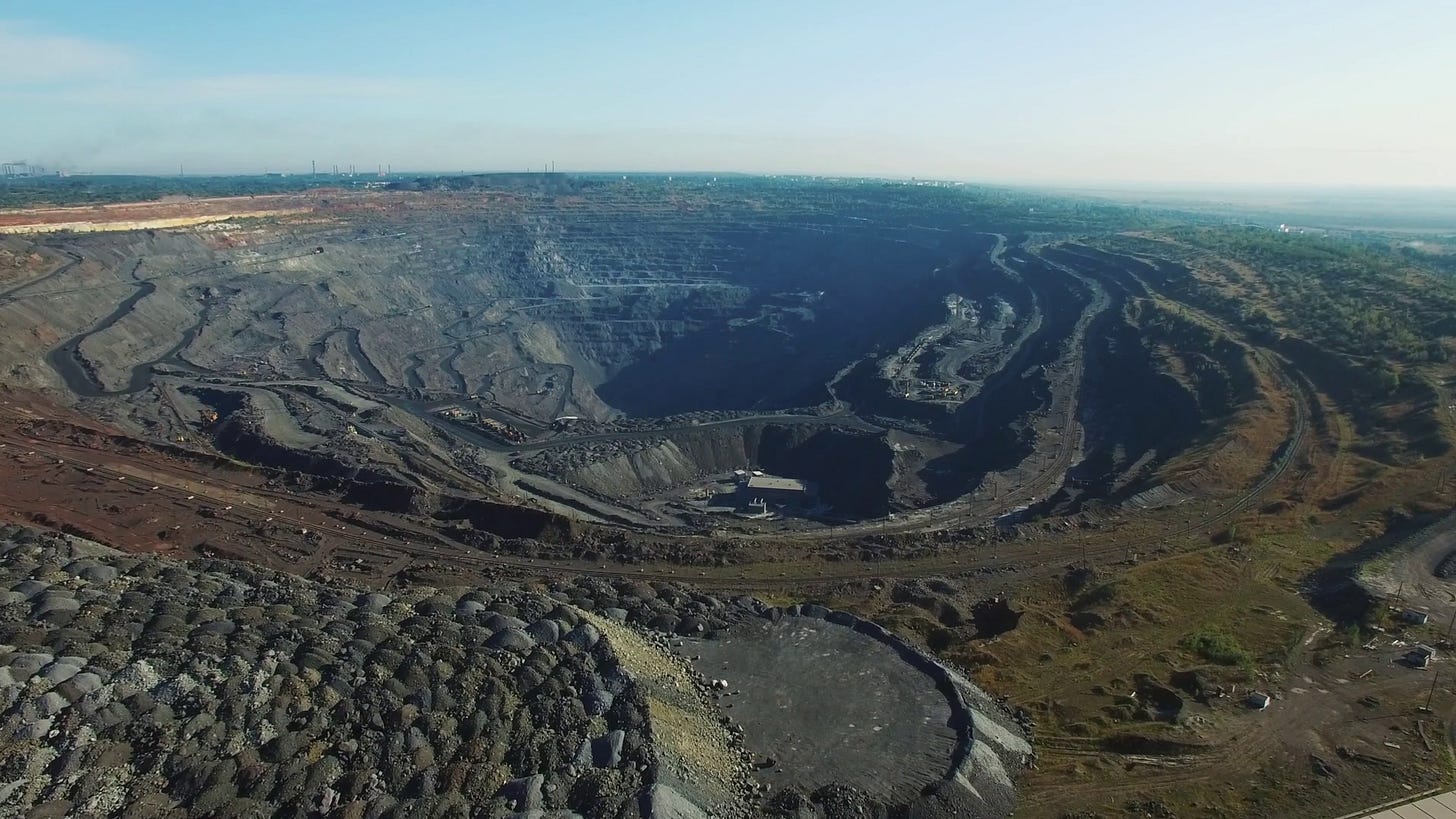 Aerial of very black, huge open pit coal mine