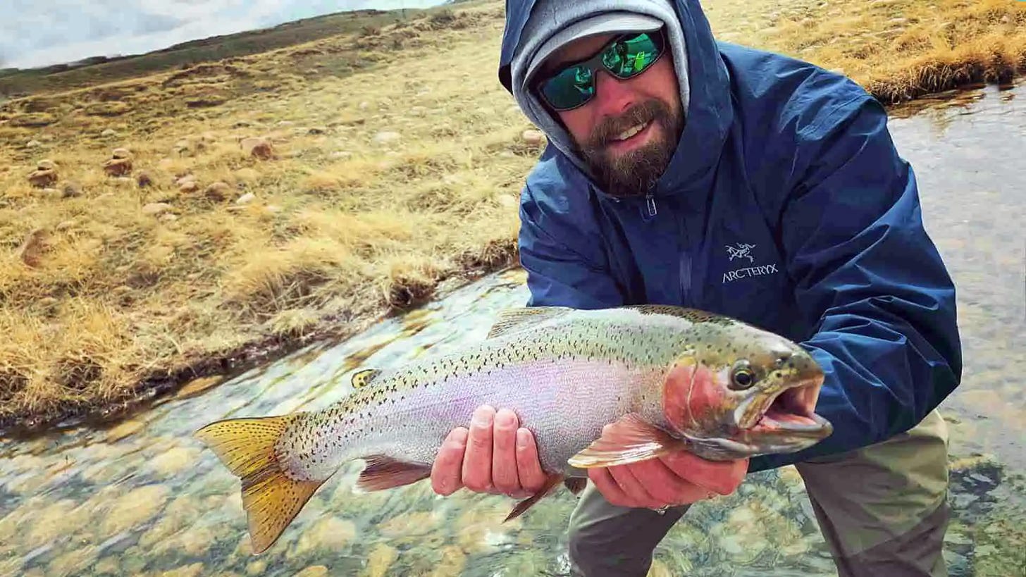 Angler with Blue Coat on with Bright Rainbow