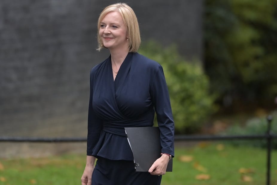 A woman clutching a file in her left hand smiles as she walks.