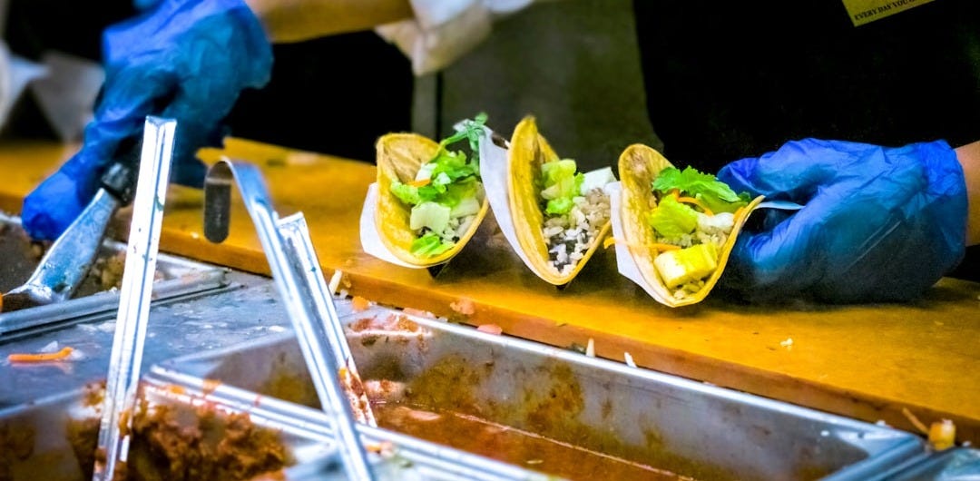 person about to put sauce on tacos person about to put sauce on tacos