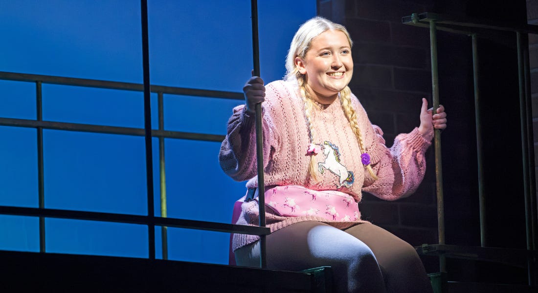 A girl in a pink jumper sitting on a stage raft A girl in a pink jumper sitting on a stage raft
