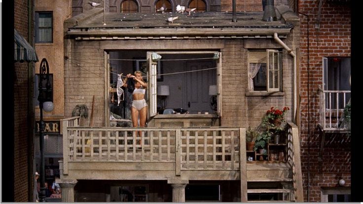 This may contain: a woman standing on the balcony of an old building