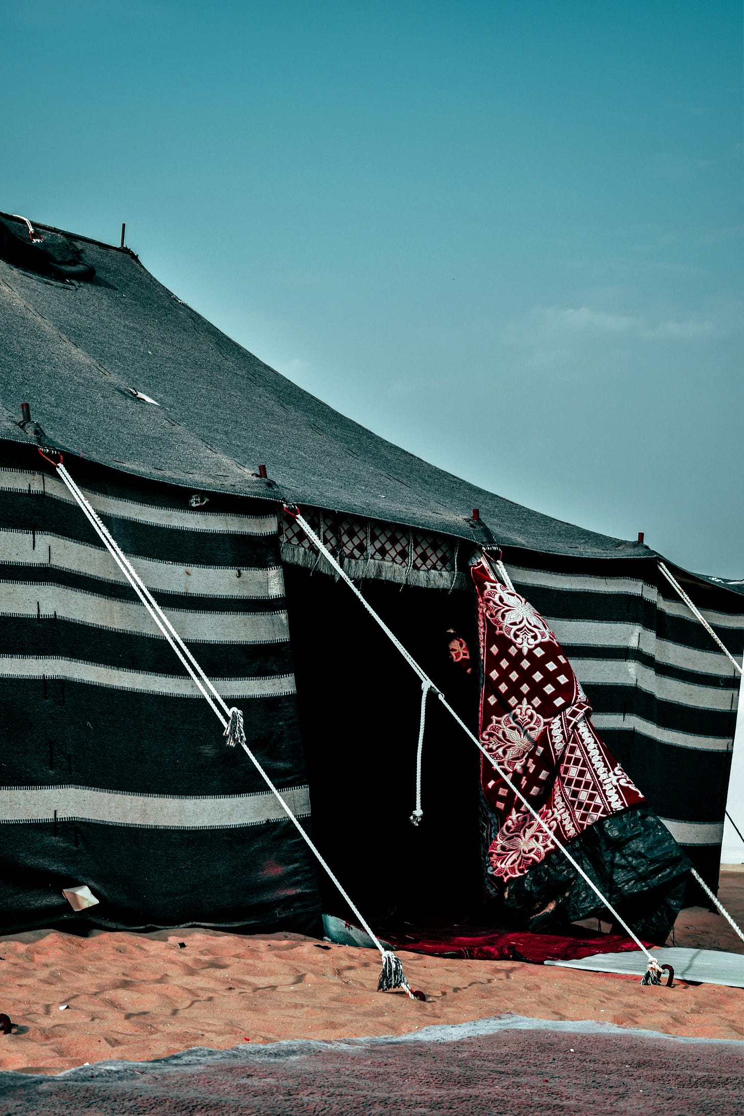 A black and white striped tent in the desert
